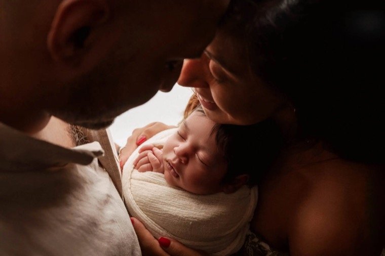 Newborn baby photo at home with soft wraps and professional lighting
